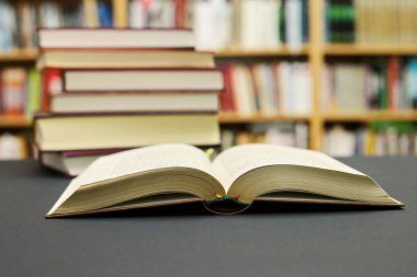 Kütüphanede siyah bir arkaplan üzerine açık bir kitap