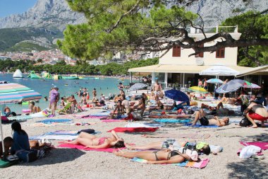 Makarska, Hırvatistan, 3 Ağustos 2020 Turistler yaz tatilinin tadını çıkarıyorlar. Hırvatistan 'da güneşleniyorlar ve denizde yüzüyorlar.