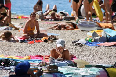 Makarska, Hırvatistan, 06.08.2020. Tatildeki turistler deniz kenarındaki kumsalın tadını çıkarın.