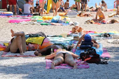 Makarska, Hırvatistan, 06.08.2020. Tatildeki turistler deniz kenarındaki kumsalın tadını çıkarın.