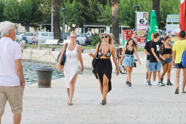 Rıhtım boyunca yürüyen turistler