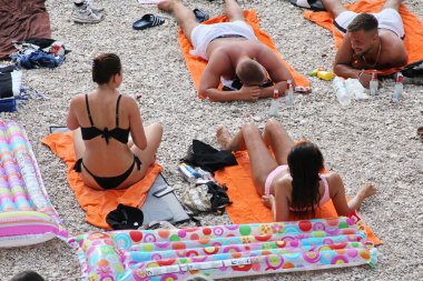 Makarska, Hırvatistan, 11.08.2020. Turistler sahilde güneşin ve denizin tadını çıkarırlar.