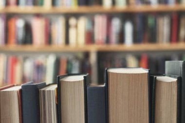 Kütüphanedeki ahşap bir rafta kitaplar..