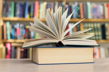 Kütüphane arkaplanlı ahşap masa üzerine kitap