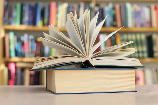 Kütüphane arkaplanlı ahşap masa üzerine kitap