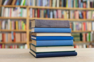 Tahta bir masanın arka planında arka arkaya dizilmiş kitaplar. Beyaz arka plan, eğitim, okuma, yüksek kaliteli kitaplar, okul, kütüphane, William Shakespeare, edebiyat, 