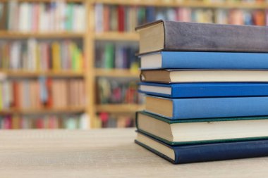 Tahta bir masanın arka planında arka arkaya dizilmiş kitaplar. Beyaz arka plan, eğitim, okuma, yüksek kaliteli kitaplar, okul, kütüphane, William Shakespeare, edebiyat, 