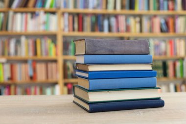 Tahta bir masanın arka planında arka arkaya dizilmiş kitaplar. Beyaz arka plan, eğitim, okuma, yüksek kaliteli kitaplar, okul, kütüphane, William Shakespeare, edebiyat, 