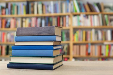 Tahta bir masanın arka planında arka arkaya dizilmiş kitaplar. Beyaz arka plan, eğitim, okuma, yüksek kaliteli kitaplar, okul, kütüphane, William Shakespeare, edebiyat, 