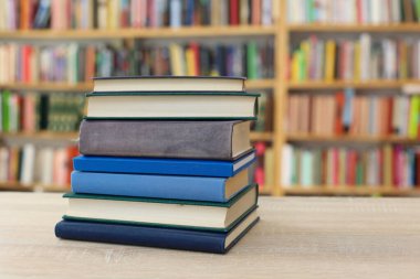 Tahta bir masanın arka planında arka arkaya dizilmiş kitaplar. Beyaz arka plan, eğitim, okuma, yüksek kaliteli kitaplar, okul, kütüphane, William Shakespeare, edebiyat, 