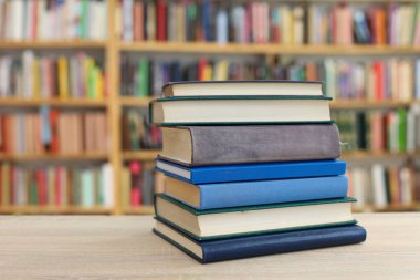 Tahta bir masanın arka planında arka arkaya dizilmiş kitaplar. Beyaz arka plan, eğitim, okuma, yüksek kaliteli kitaplar, okul, kütüphane, William Shakespeare, edebiyat, 