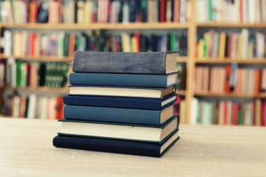 Tahta masanın önünde bir yığın kitap.