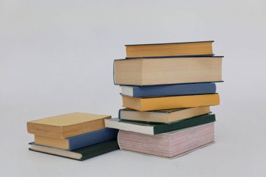 Dünyanın en ünlü yazarlarından okumaya hazır güzel bir kitap seti kütüphane arka planındaki ahşap masanın üzerinde kitap ve gözlük yığını. eğitim ve bilgi kavramı, kütüphane, okul