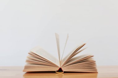 Beyaz masanın üzerinde bir yığın eski kitabın olduğu açık bir kitap. Okula geri dön.