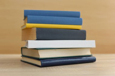 Kütüphanedeki ahşap masada yığınla kitap.