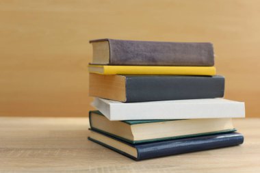 Tahta masadaki kitap yığını.