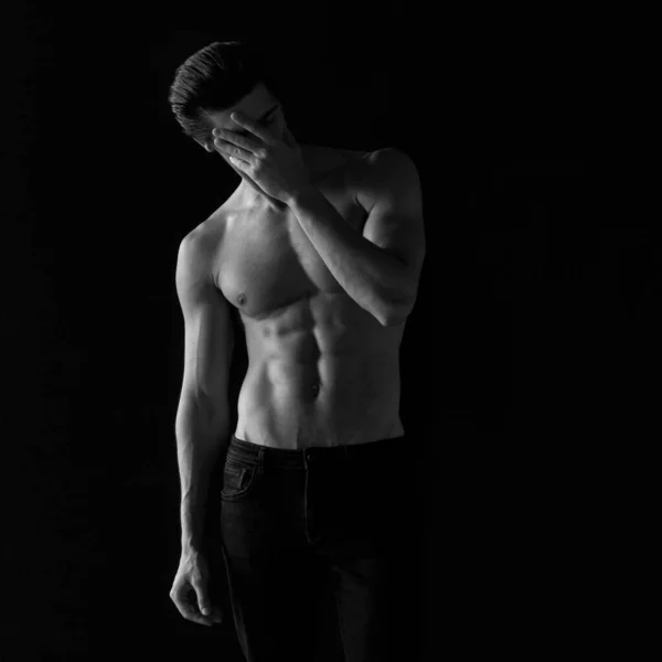 Portrait of an athletic man with a shirtless tanned torso. Studio shoot. Black and white photo. — Stock Photo, Image