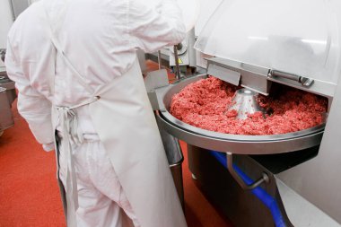 Process for the production of products of animal origin. Raw meat minced in an industrial process factory stored in a stainless steel crate at a processing. clipart