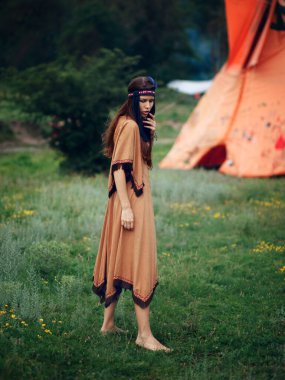 Güzel bir kızın portresi. Amerikan yerlisi, geleneksel elbiseli Hintli kadın, vahşi ormanda poz veriyor..