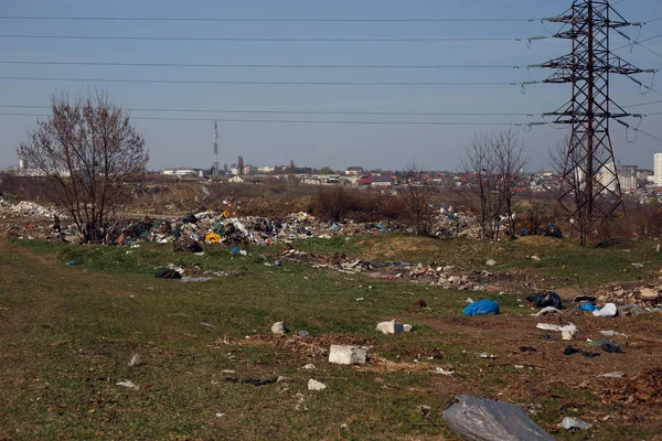 Çöplerle, lastiklerle ve plastik poşetlerle kaplı bir arazi şehrin arka planına fırlatıldı. Metin için boşluk.