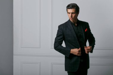 Siyah takım elbiseli özgüvenli bir adam koyu bir arka planda. Yakından bir portre yakışıklı adam. Yatay görünüm.