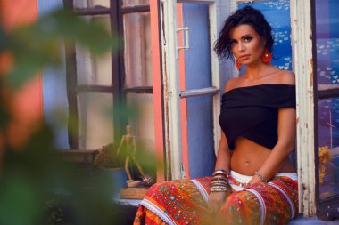 Güzel, şehvetli, esmer bir kızın portresi, profesyonel, hassas makyaj ve moda kıyafeti. Çingene tarzı.