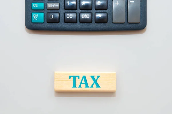 計算機とお金の単語Taxと木製のブロック 租税計画 還付金又は租税の概念 — ストック写真