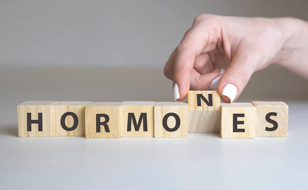 Hormones Word Written In Wooden Cube on white.