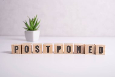 Ertelendi - harfli tahta bloklardan kelimeler, ertelenmiş konsept, üst görünüm arka plan.