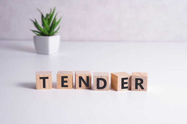 Буква в слове тендер на деревянном фоне.