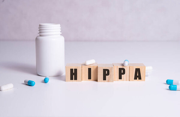 Wooden block form the word HIPAA Health Insurance Portability and Accountability Act on white. Medical concept.