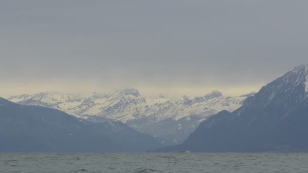 Pan Αριστερά Των Βουνών Που Καλύπτονται Χιόνι Κοντά Στη Λίμνη — Αρχείο Βίντεο