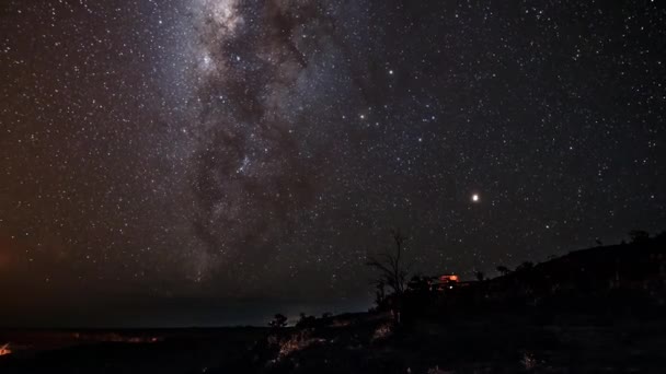 天の川が動く映像 木々の上に落ちる星と雲の層シルエットと孤独な家 — ストック動画