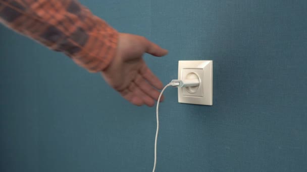 Een Man Haalt Een Telefoonoplader Uit Een Stopcontact Rosette Muur — Stockvideo