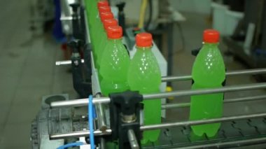 Limonata Soda Şişeleri, taşıma bandı boyunca ilerler. Üretimde paketlenmiş bükümlerle doludur.