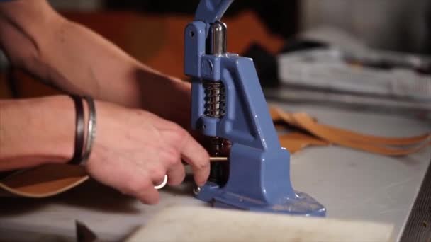 Řemeslník používá ruční lis pro instalaci kovových armatur na kůži — Stock video