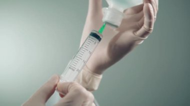 Doktor şırıngada ilacı alır ve iğneye hazırlanır.