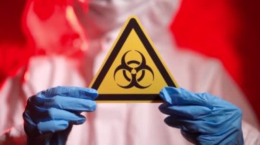 Koruyucu Takım Elbiseli Enfeksiyoncu Doktor Biyolojik Tehlike İşareti Gösteriyor
