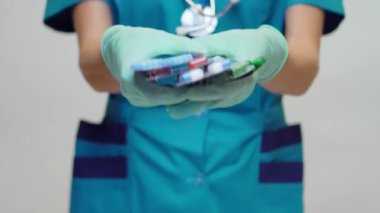 Koruyucu Maske ve Lastik Eldiven Giyen Doktor Hemşire Kadın veya Lateks Eldiven Tutma Hapları 