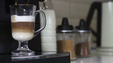 Kahve makinesinden kapuçino bir bardağa doldurulur.