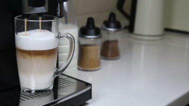 Kahve makinesinden kapuçino bir bardağa doldurulur. 