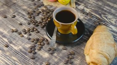 Kahve, kruvasan ve ahşap masada dönen makarna.