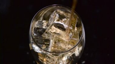 Buzlu bir bardağa kola döküldü. Kara Arkaplan. Üst Görünüm