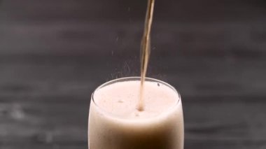 Buzlu kolayla bardağa doluyor ve köpükle doluyor.