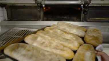 Dişi fırıncı fırından sıcak ekmeği çıkardı.