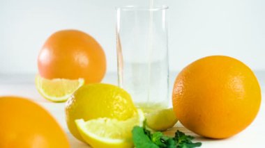  Citrus Meyveleri 'nin yanında, Bardaktaki Portakal Suyu' nun Beyaz Tahta Masa 'da çekilmesi.