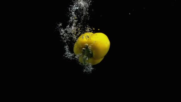 新鮮な黄色のベルペッパーは 空気の泡の多くの水に落ちる黒の背景 — ストック動画