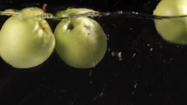 黑色水中的绿色苹果 — 图库视频影像