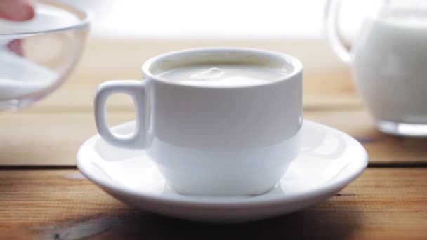 main verser le sucre par cuillère à café dans une tasse de café 