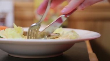 Çatal ve bıçakla salata yiyen adam.